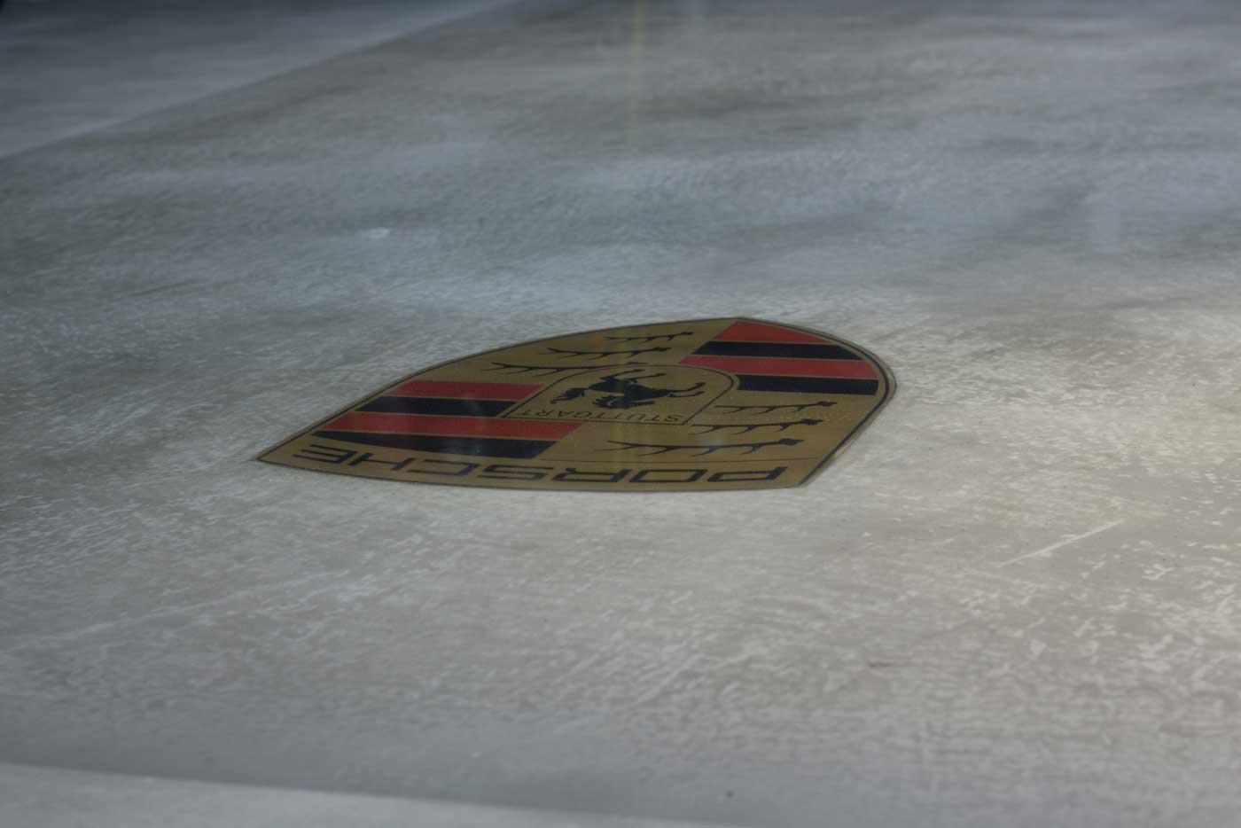 gespachteltes Porsche Logo eingelassen in den gespachtelten Boden im Loft Design